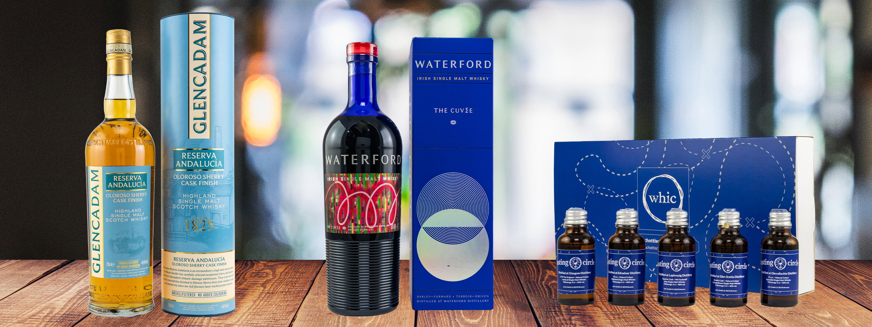 Glencadam Reserva Andalucia Oloroso Sherry Cask Finish 15 Jahre Highland Single Malt Whisky mit Tube, Waterford The Cuvée Irish Single Malt Whisky und whic Tasting Circle Set mit 4 Miniaturen auf Holztisch