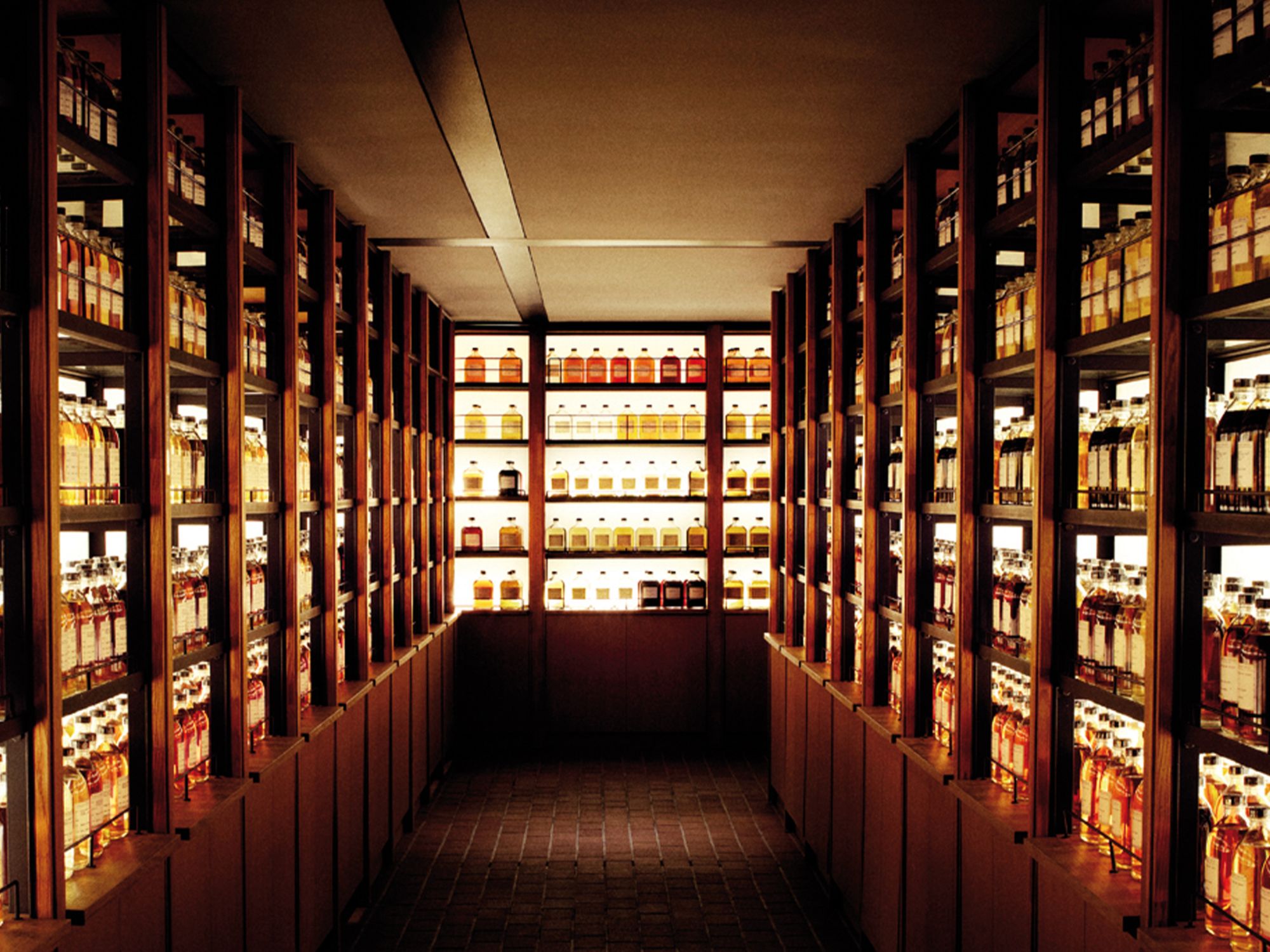 Exklusives Whisky-Archiv mit beleuchteten Holzregalen voller Premium-Single-Malt-Whiskys in edlen Flaschen, luxuriöses Ambiente für Sammler und Genießer